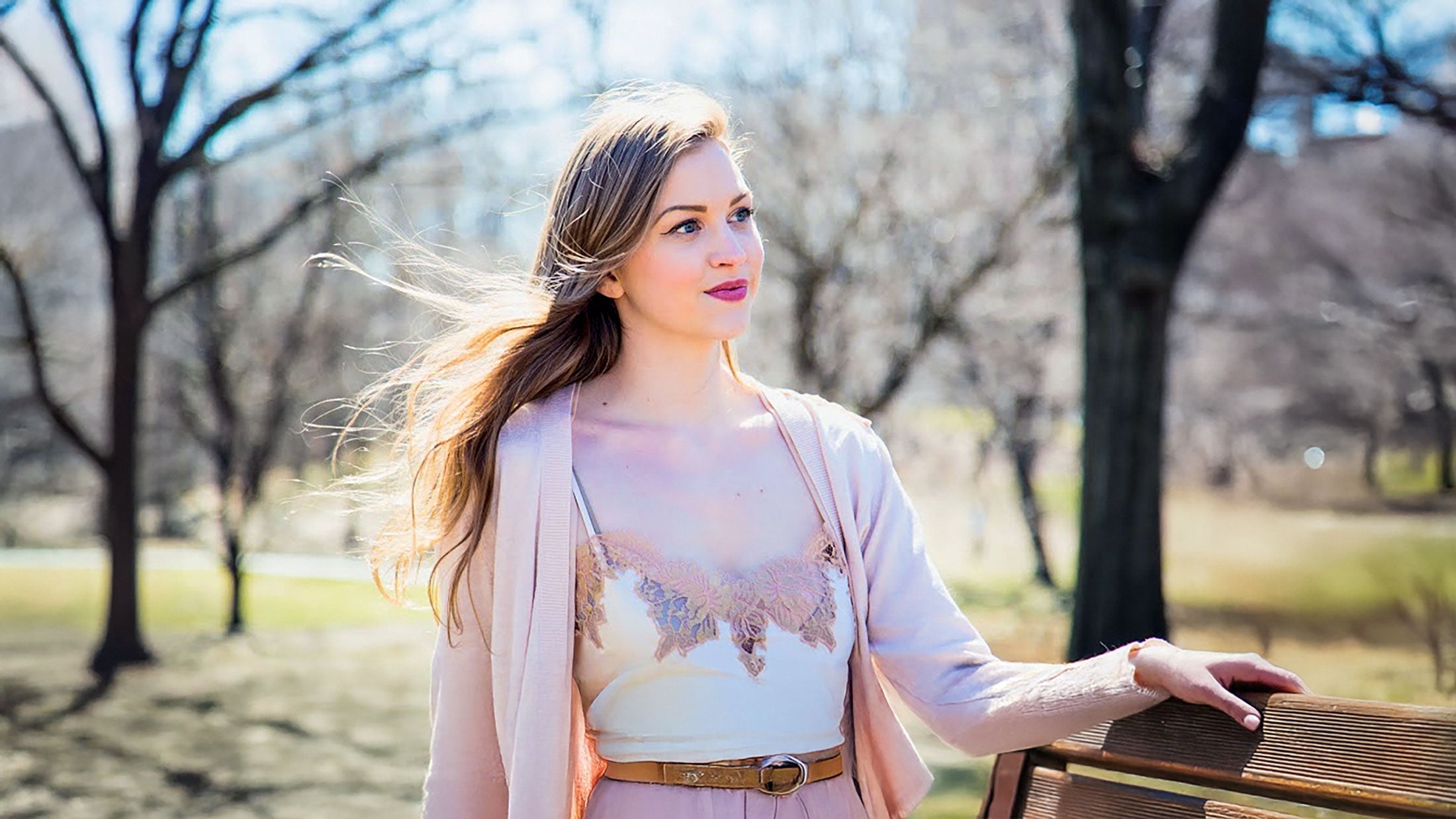 Silk cami styled as outwerwear by layering a pink sweater over the shoulders