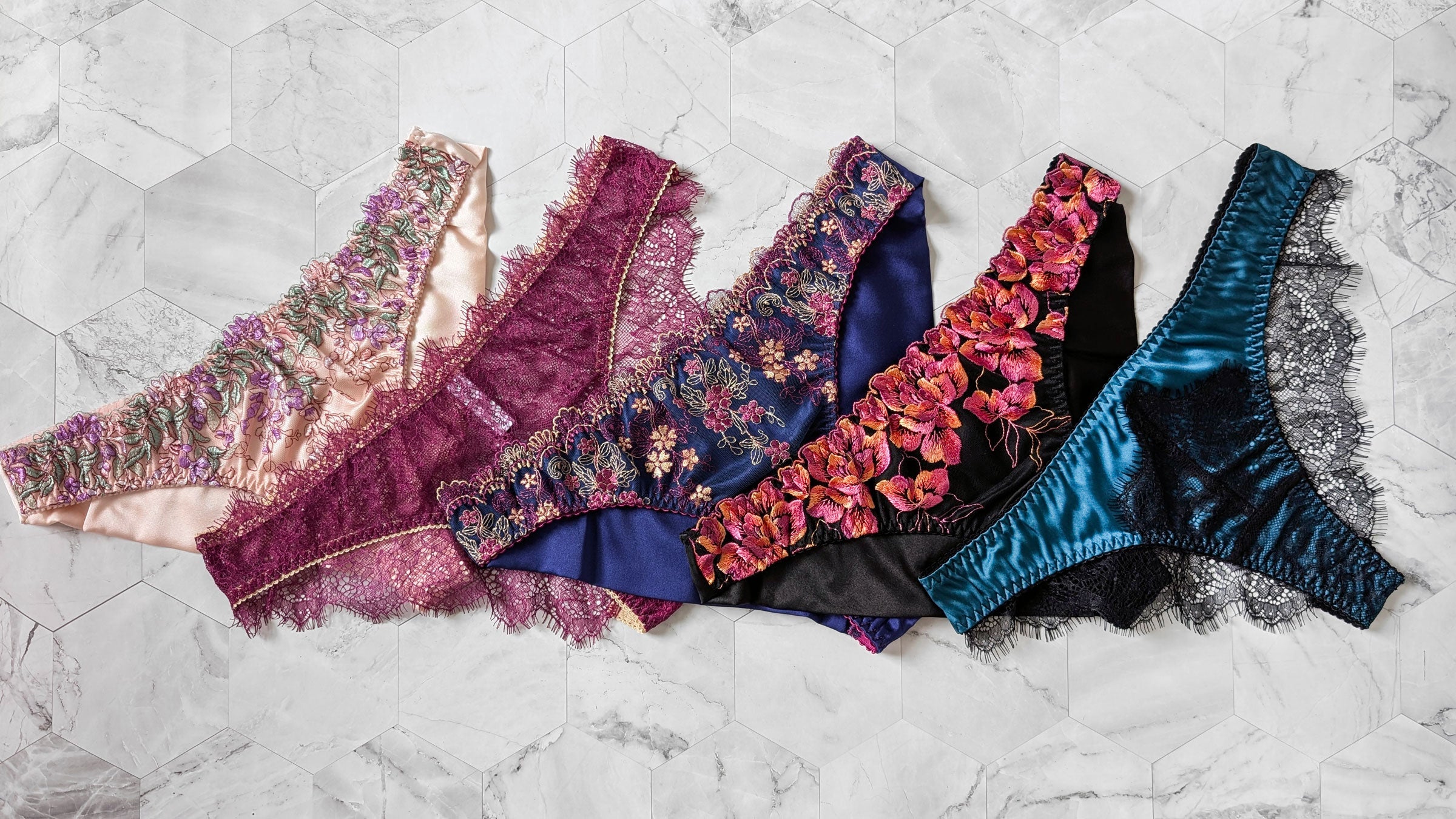 5 pairs of cheeky knickers in pink silk, magenta lace, blue embroidery, orange embroidery, and black lace