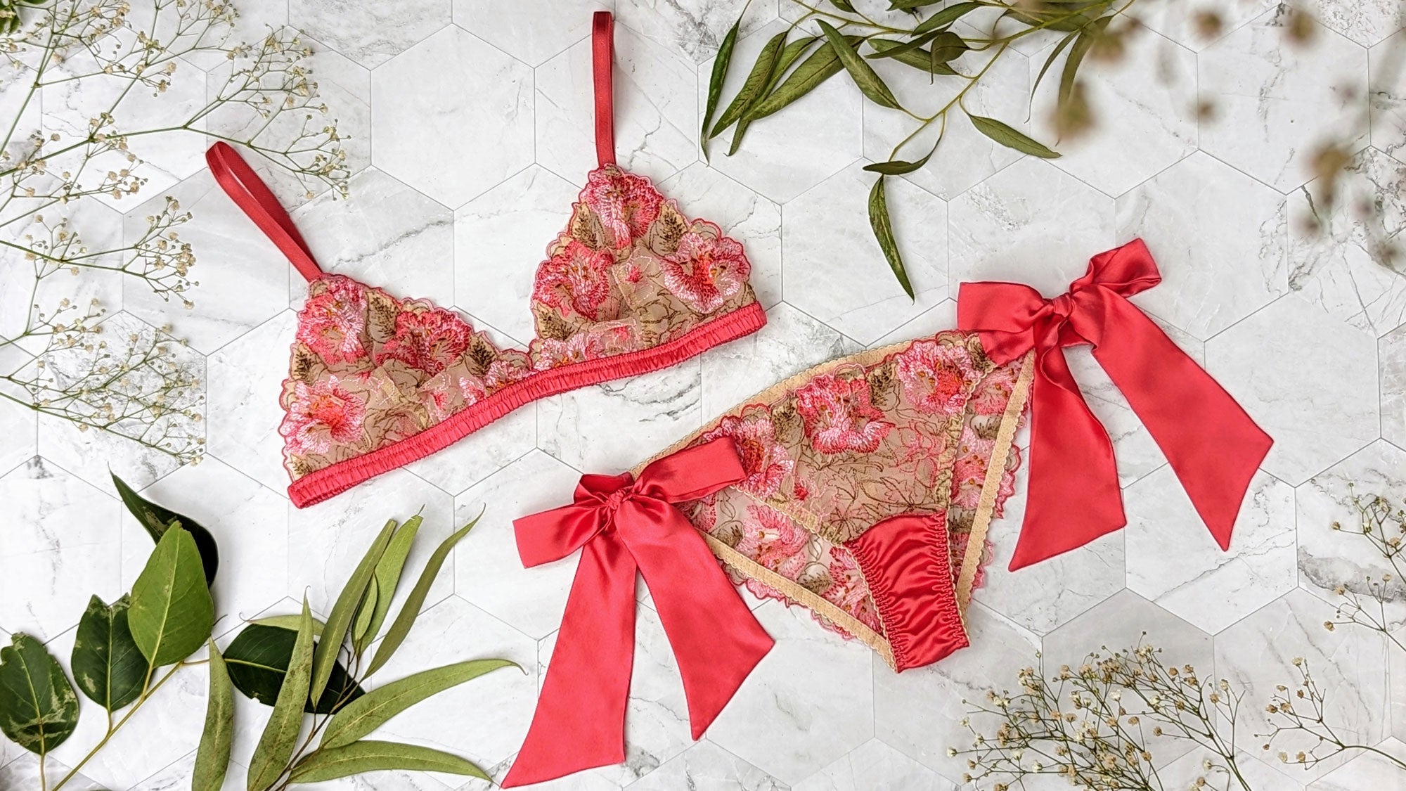 Luxury lingerie set with embroidered bralette, garter belt, and thong panties with floral trims