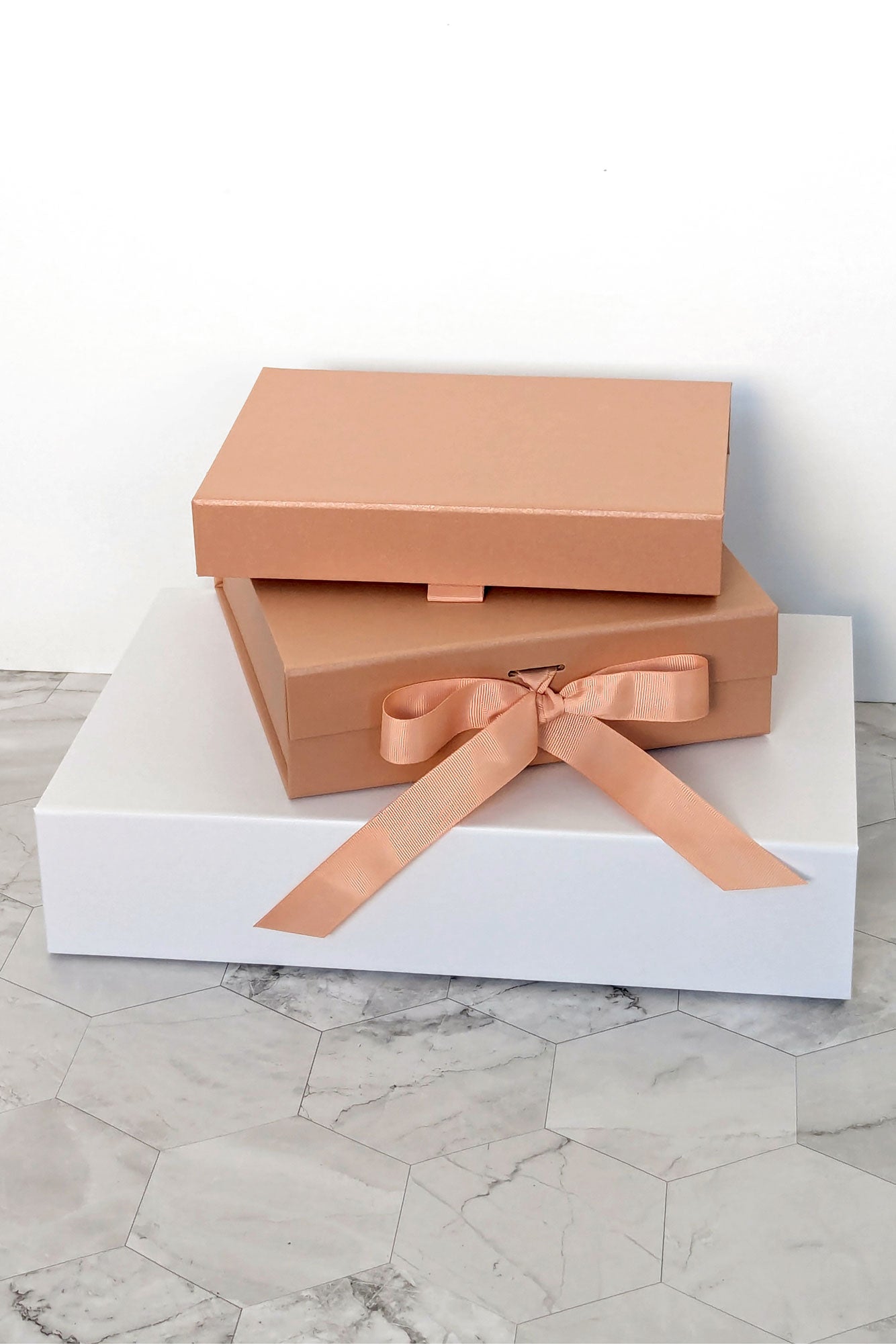 3 stacked pink and white gift boxes for lingerie sets with magnetic closures and ribbon bows
