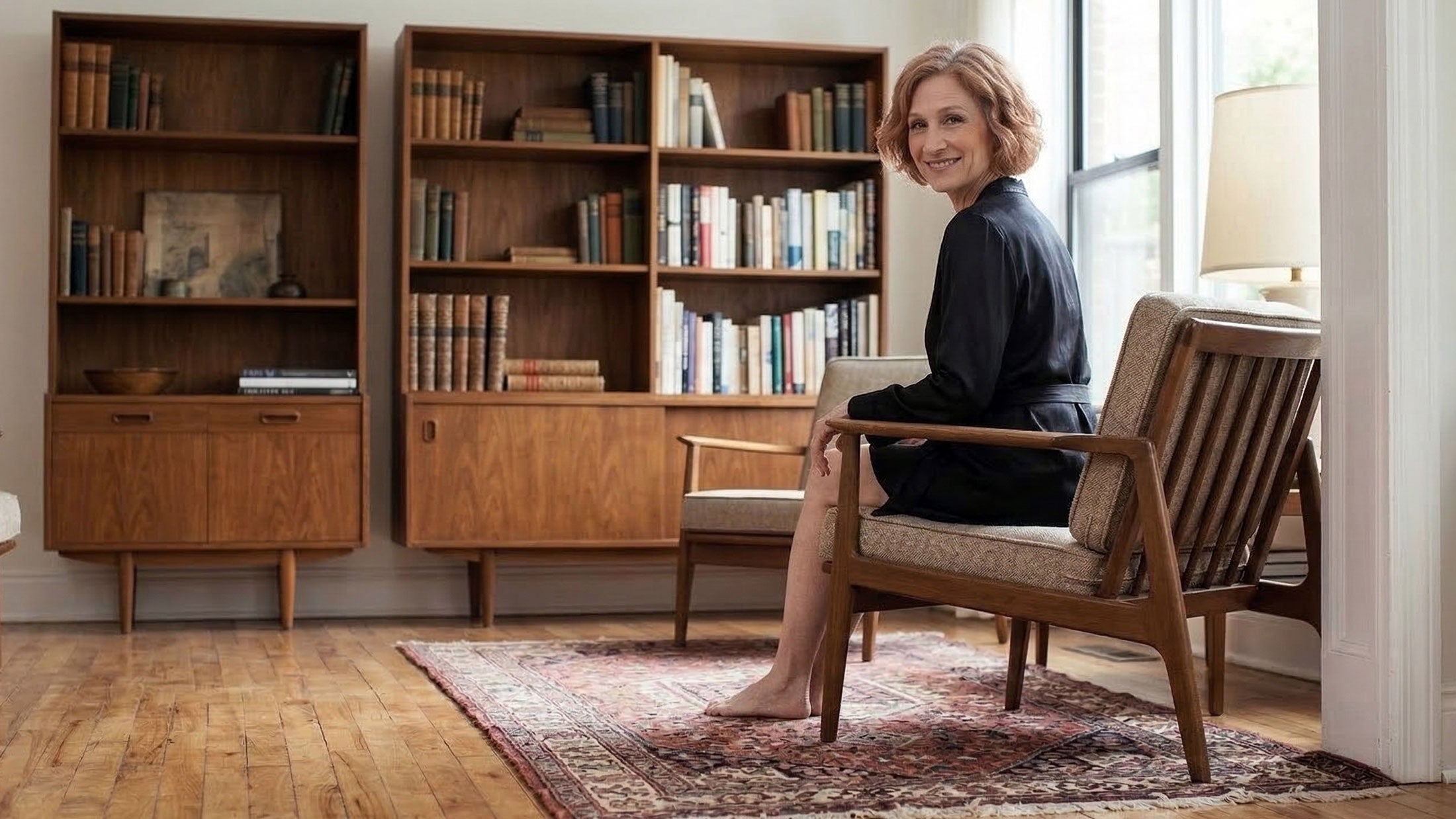 Woman sitting in a chair wearing a black silk satin robe