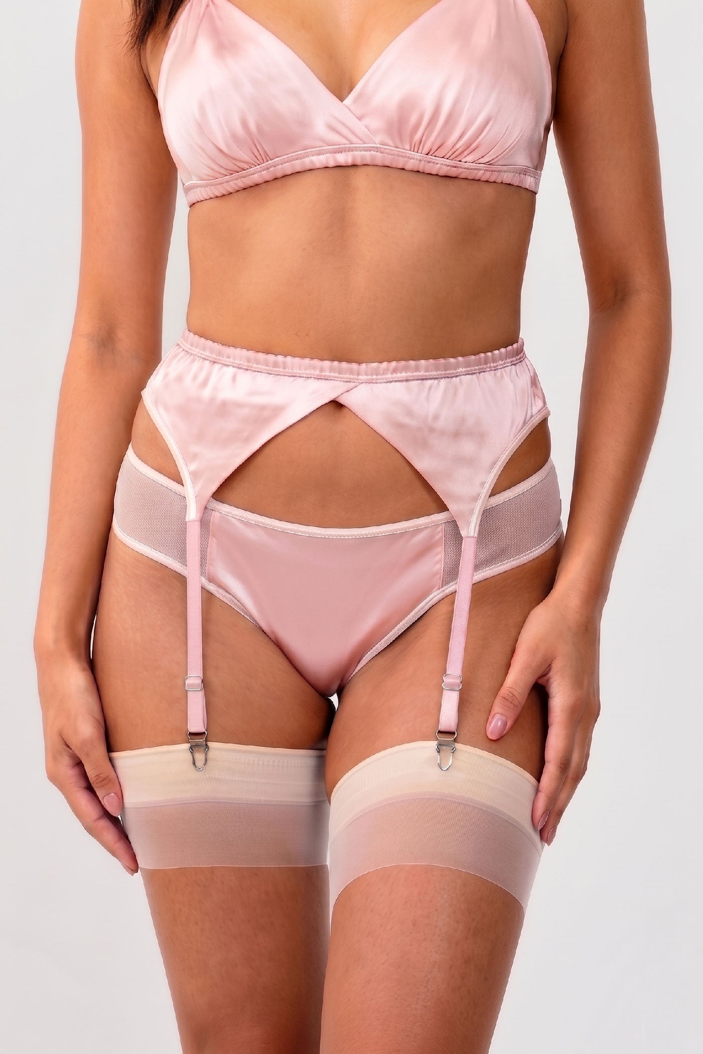 Pink silk knickers with white mesh trim and a strappy garter belt and stockings