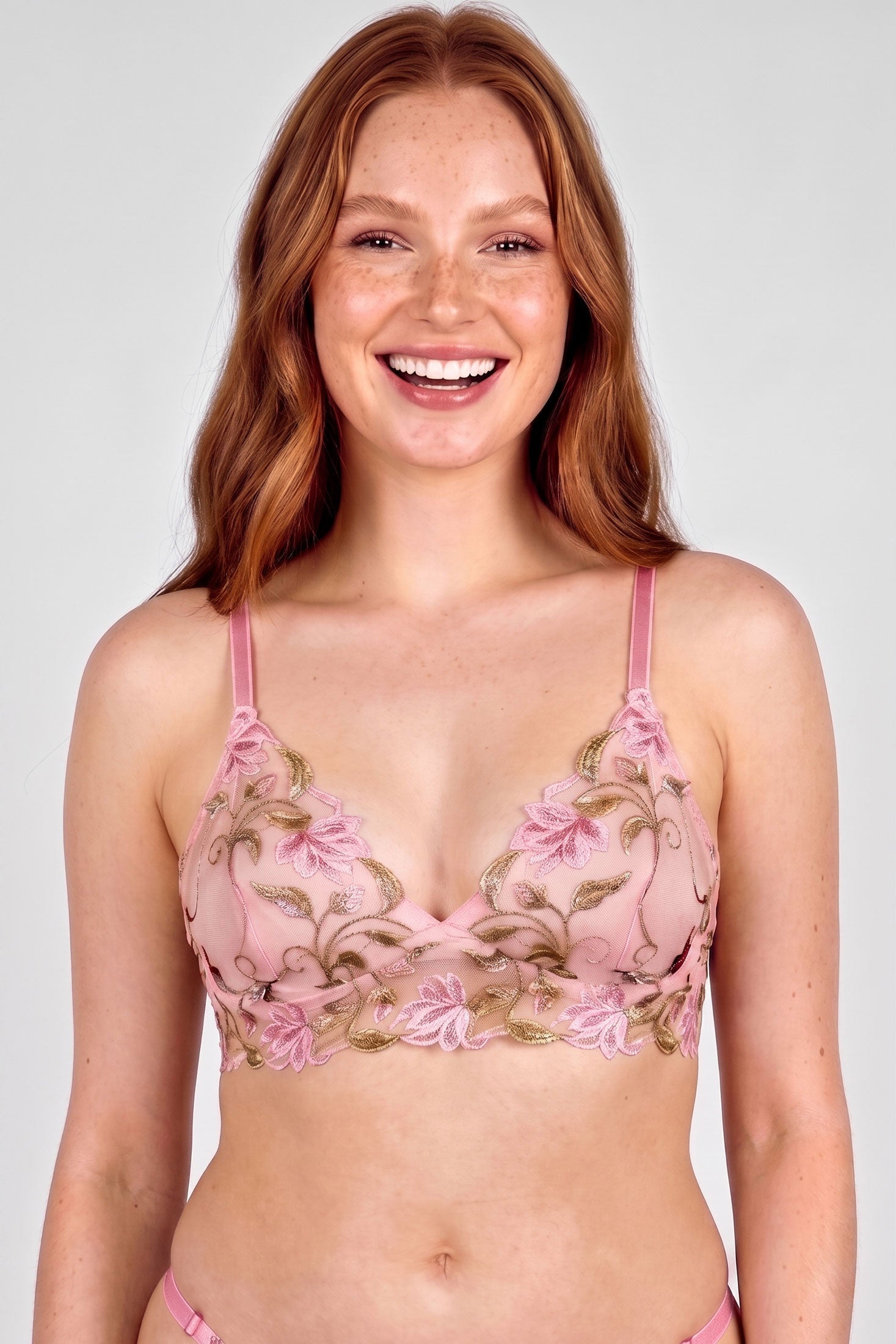 Pink and green embroidered bra with flower and vine designs and pink elastic straps
