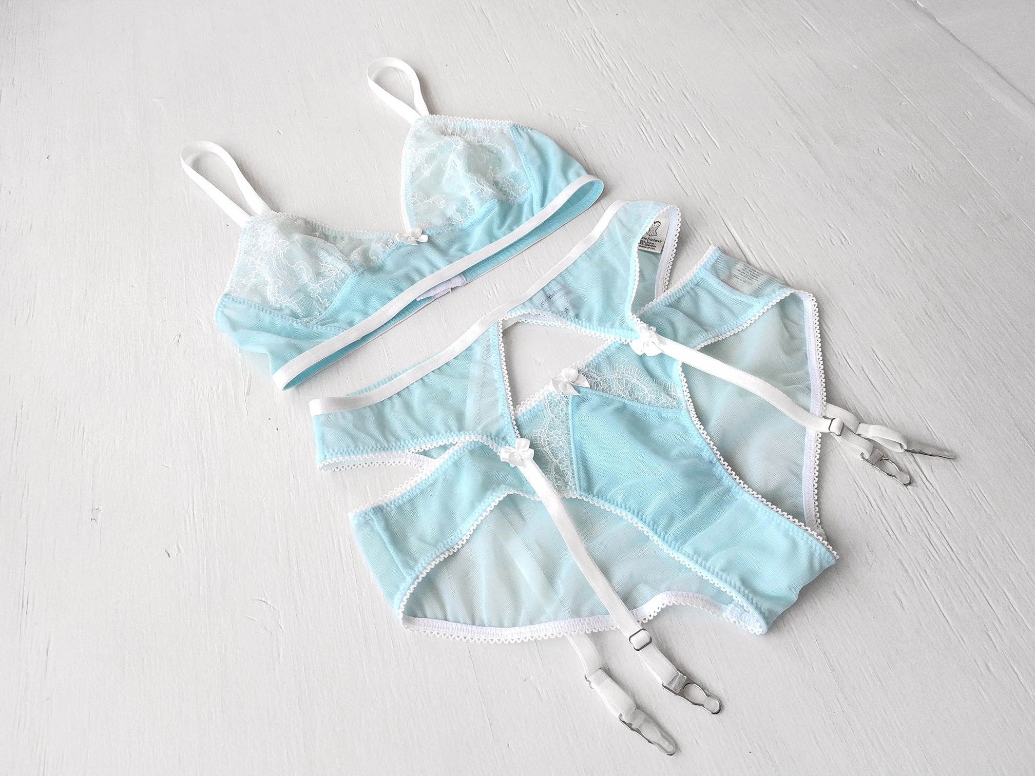 Fancy designer lingerie set in light blue mesh with suspender belt
