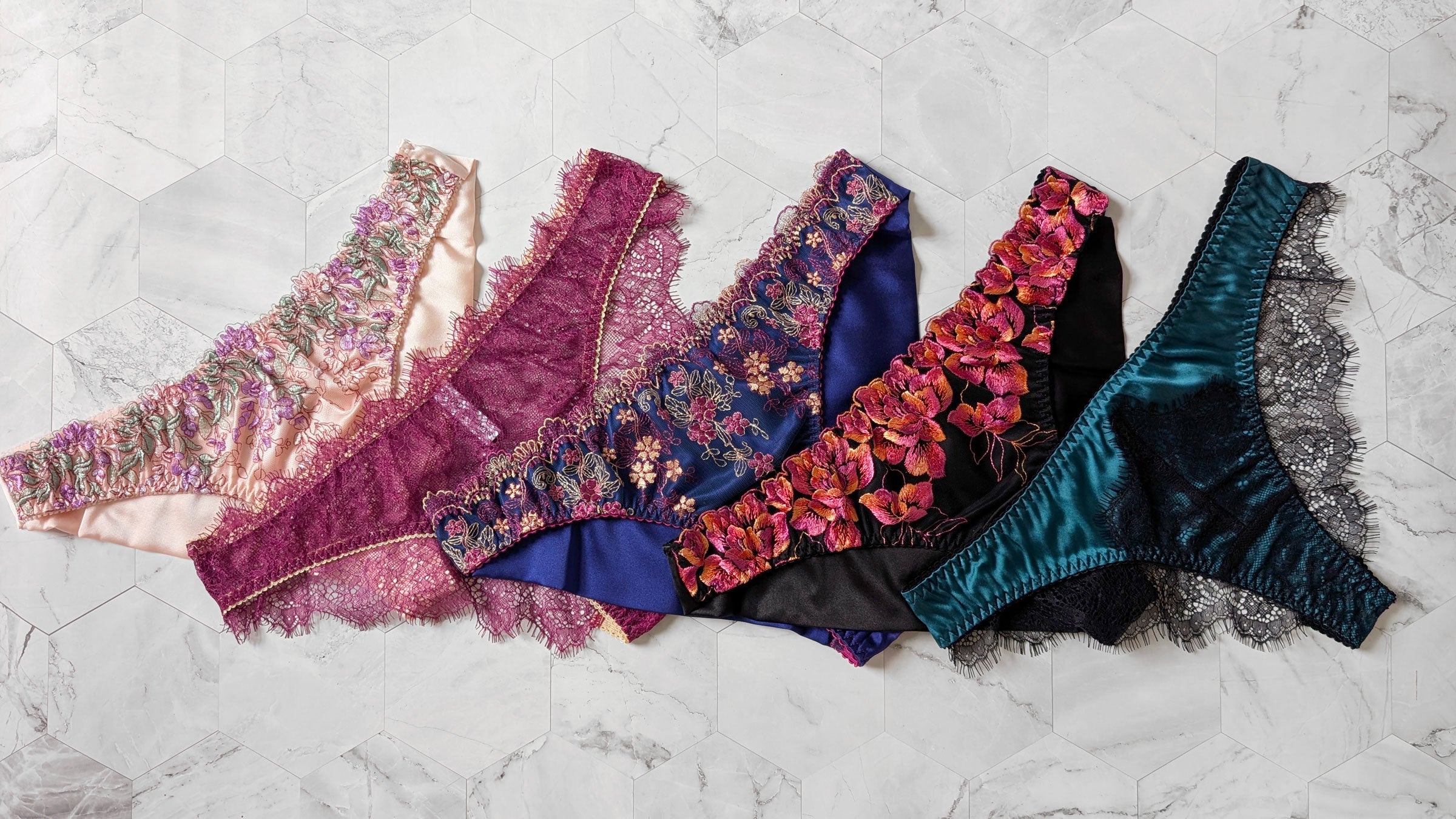 5 pairs of cheeky knickers in pink silk, magenta lace, blue embroidery, orange embroidery, and black lace