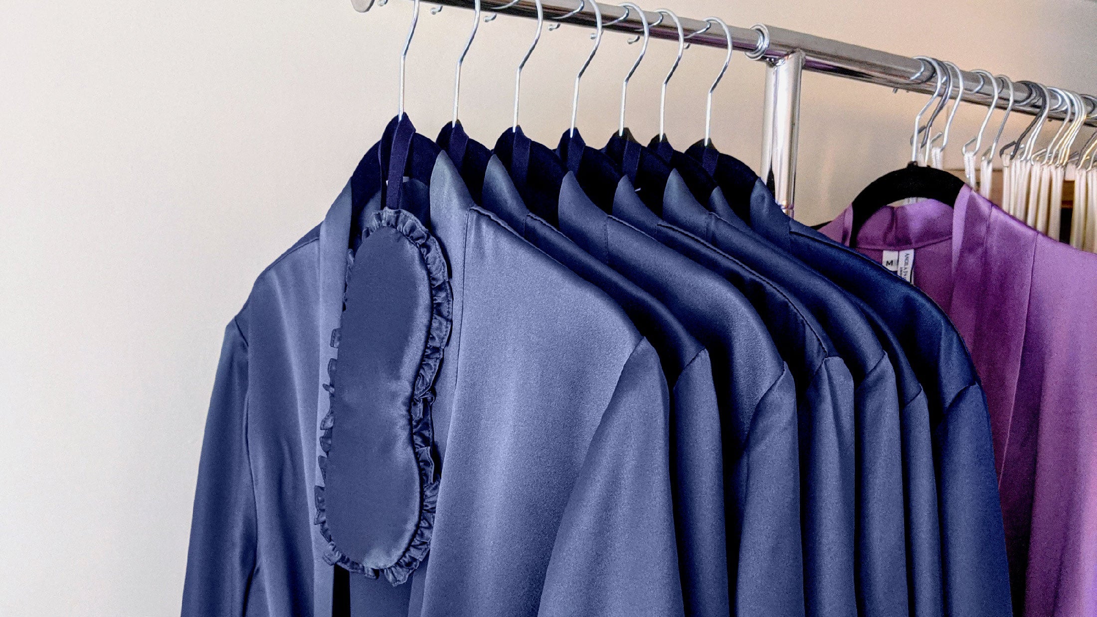 Blue silk robes on a garment rack hanging in a luxury department store rail