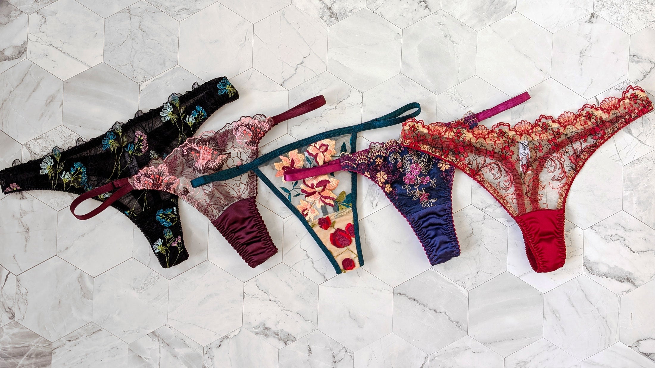 5 designer lace thongs with flower embroidery and silk trimmings in black, burgundy, teal, blue, and red