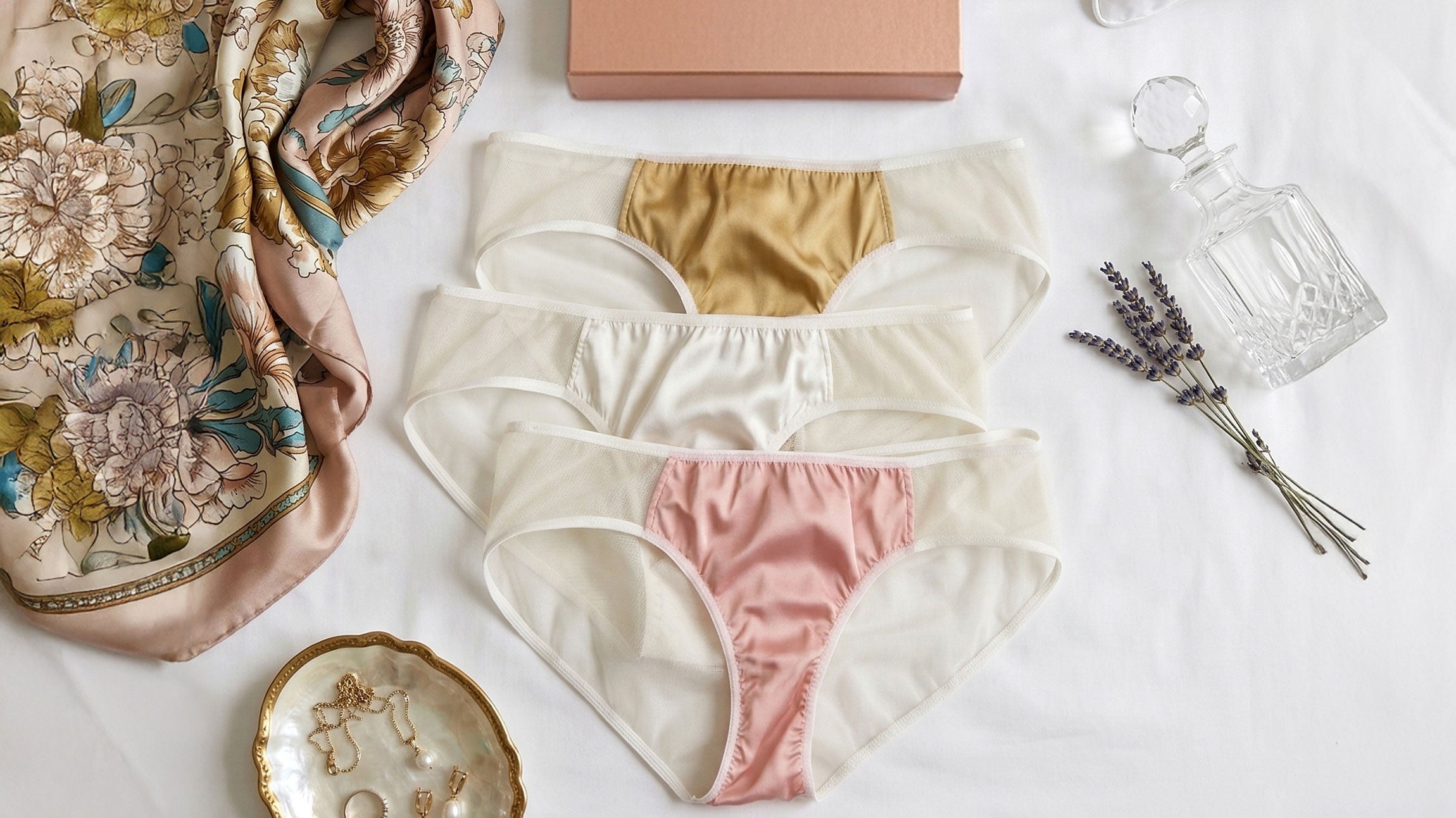 Set of women's underwear with a scarf and decorative items on a light surface