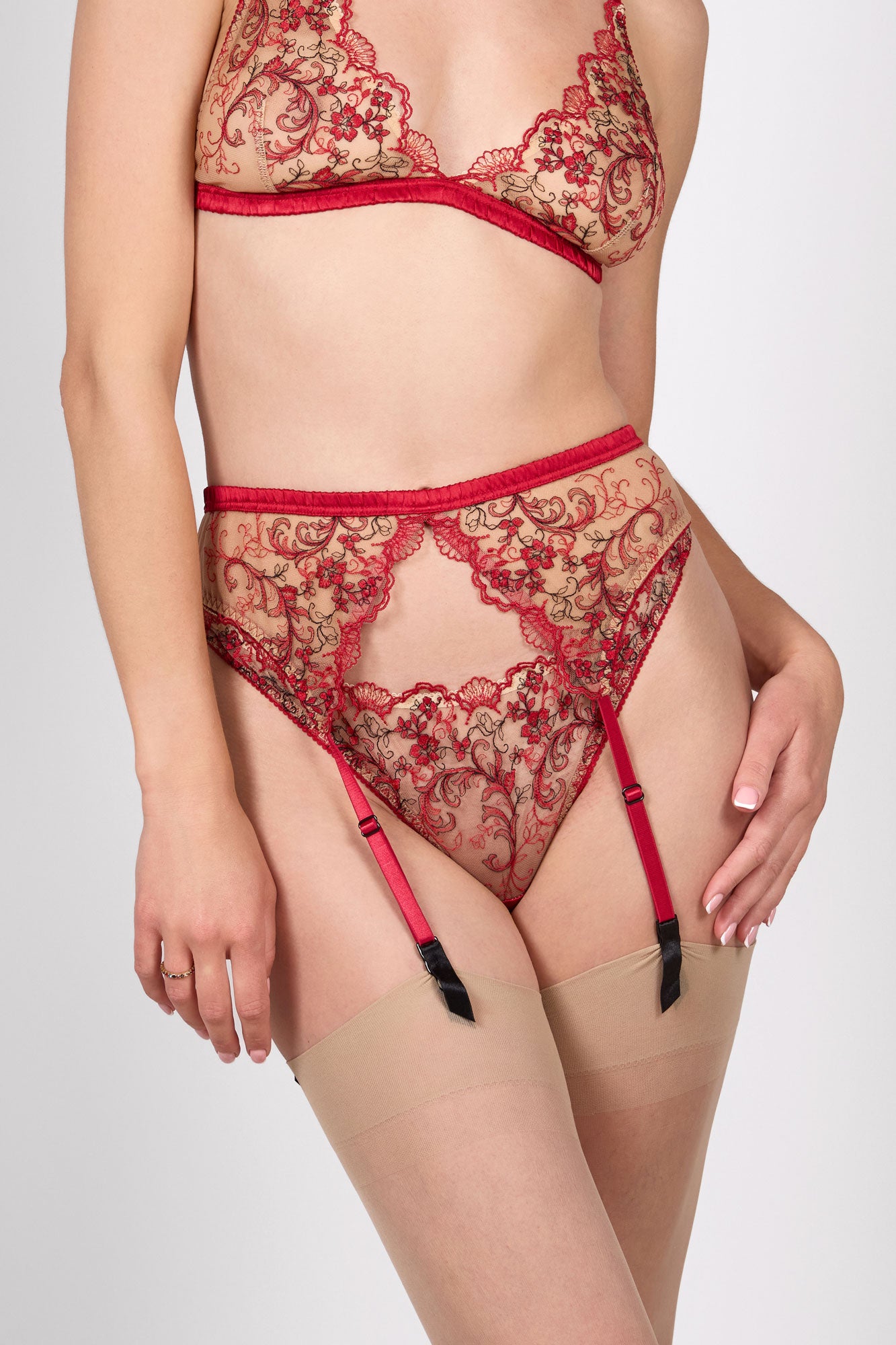 Carmen suspender belt in a vintage style with red elastics straps and metal garter clasps holding nude stockings