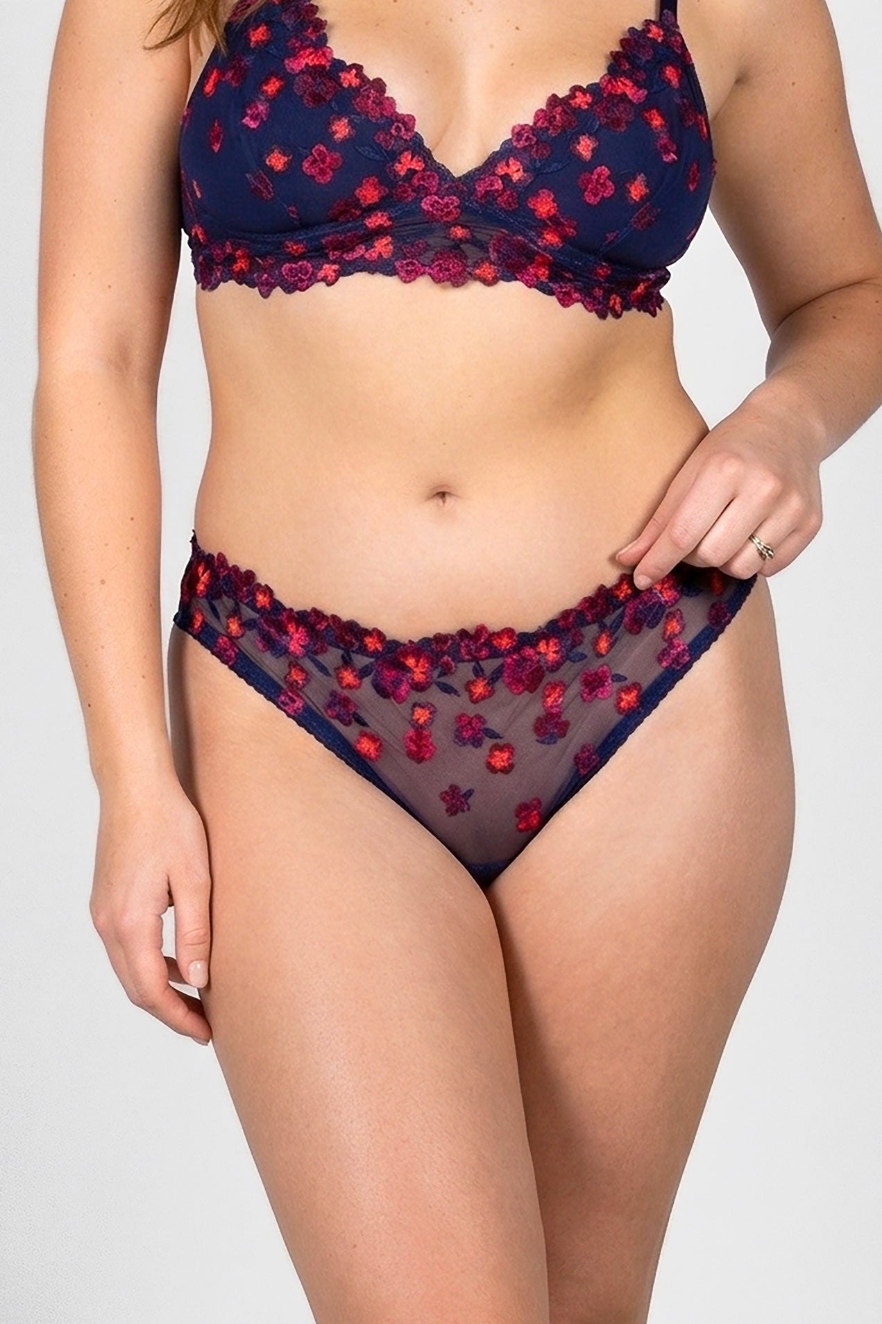 Bikini lingerie set with neon red floral pattern on a navy blue mesh background