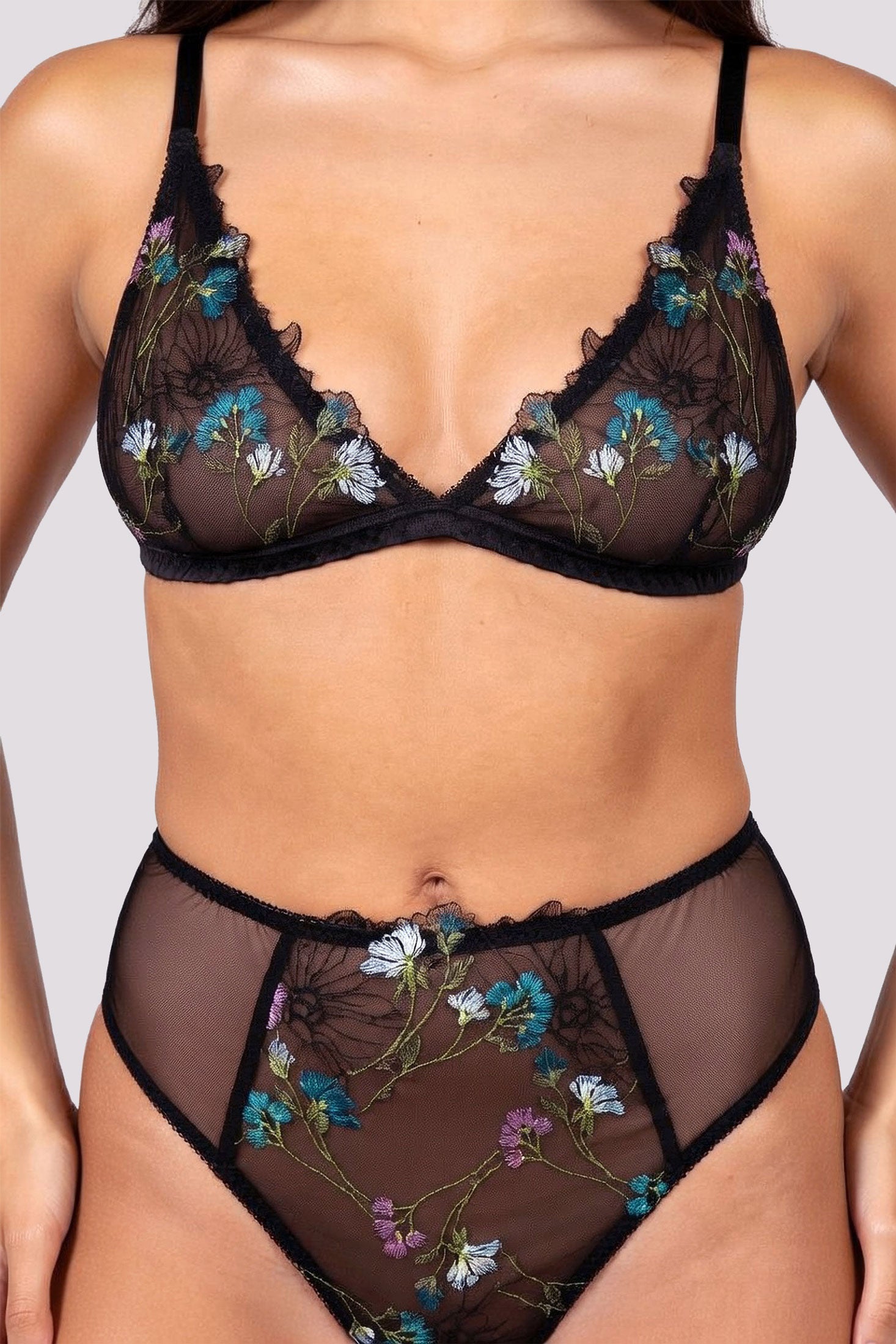 Closeup of a luxury lingerie set in floral embroidery and black mesh with silk trims