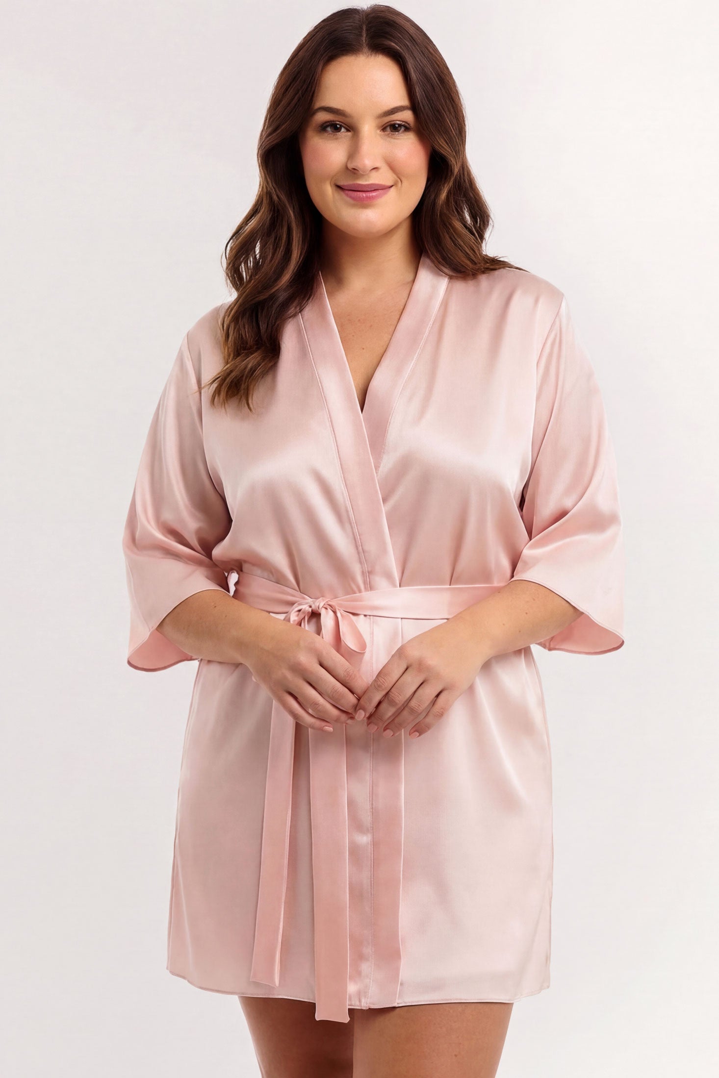 Woman wearing a pink silk robe in 100% silk satin with a tied sash belt