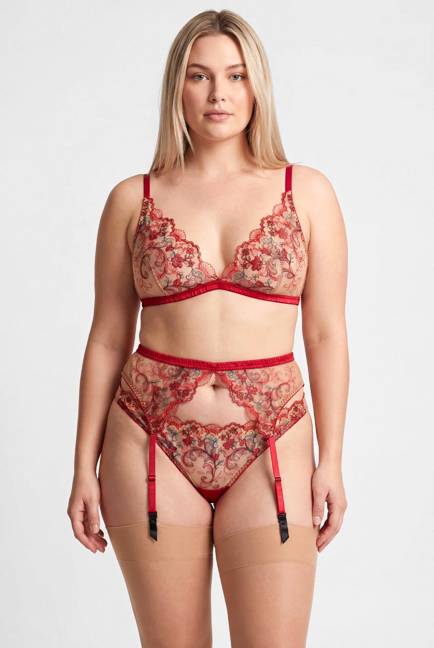 Red floral lingerie set including a bralette, suspender belt, and underwear on a size L model