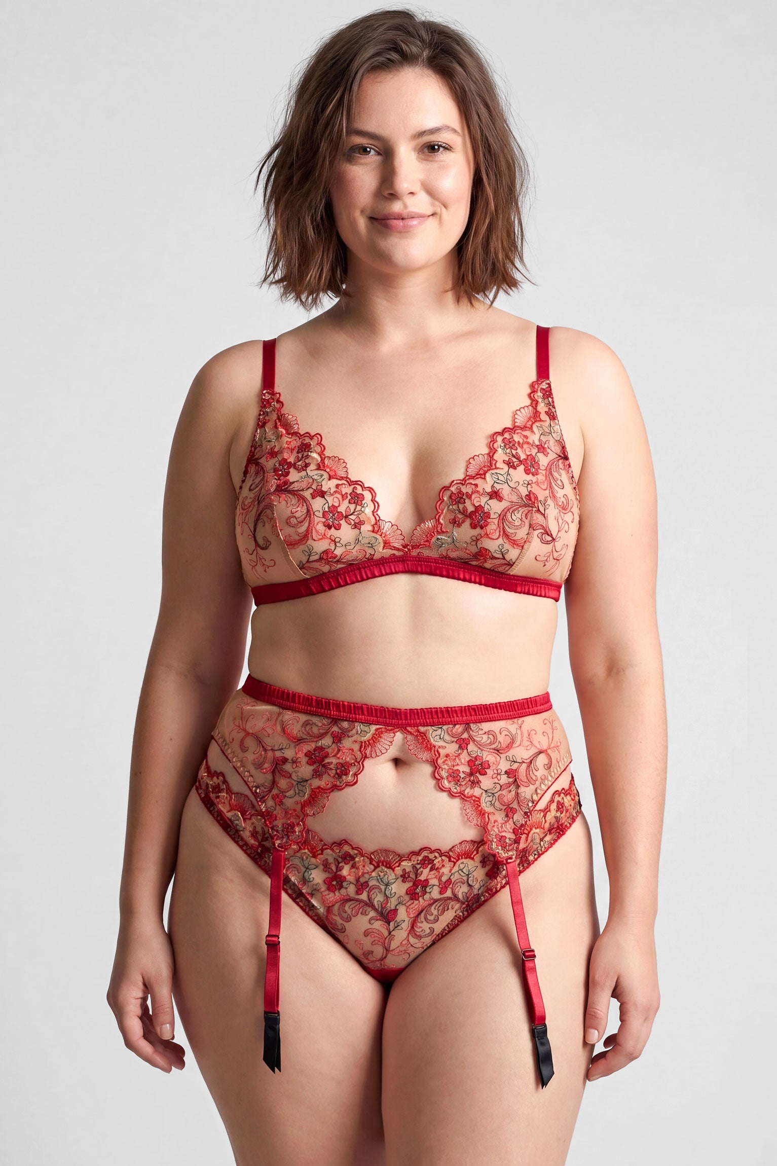 Red floral lingerie set including a bralette, suspender belt, and underwear on a size L model