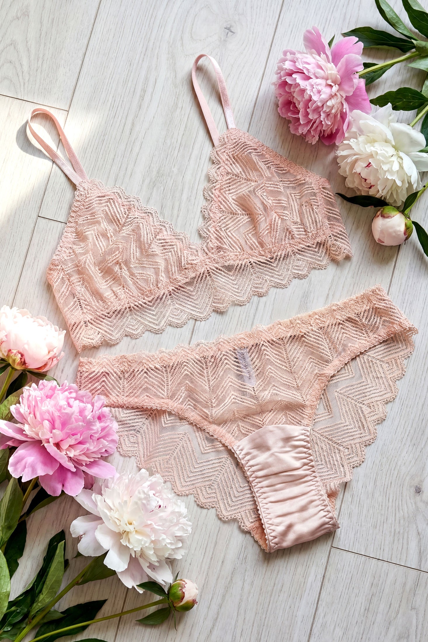 Handmade lingerie set in blush silk and stretch lace, surrounded by pink and white peonies