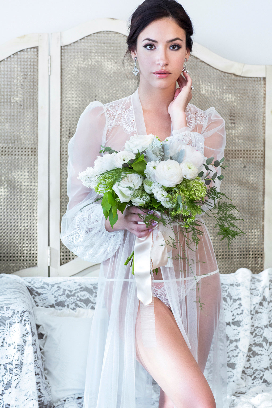 Bride getting ready outfit including a sheer peignoir robe with a white lace lingerie set and large bridal bouquet