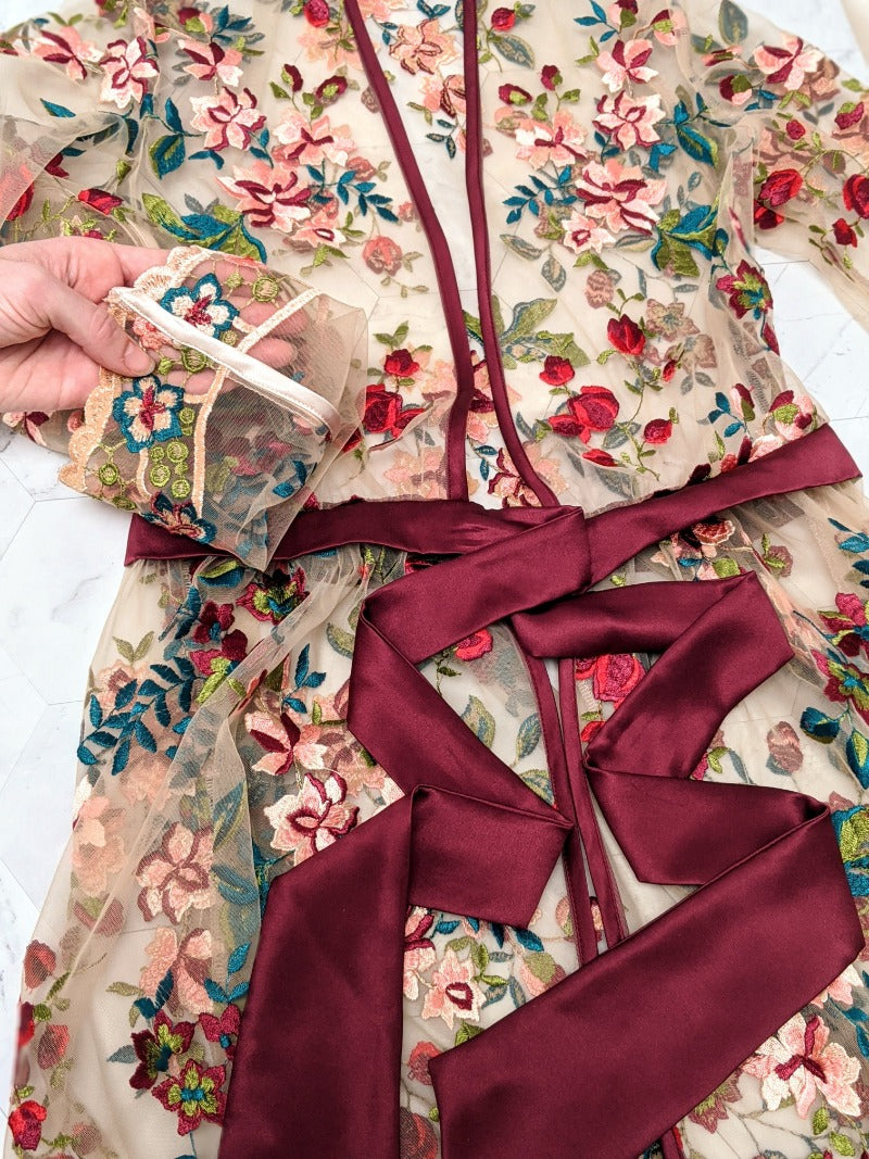 Closeup details of silk satin robe with couture embroidered flowers