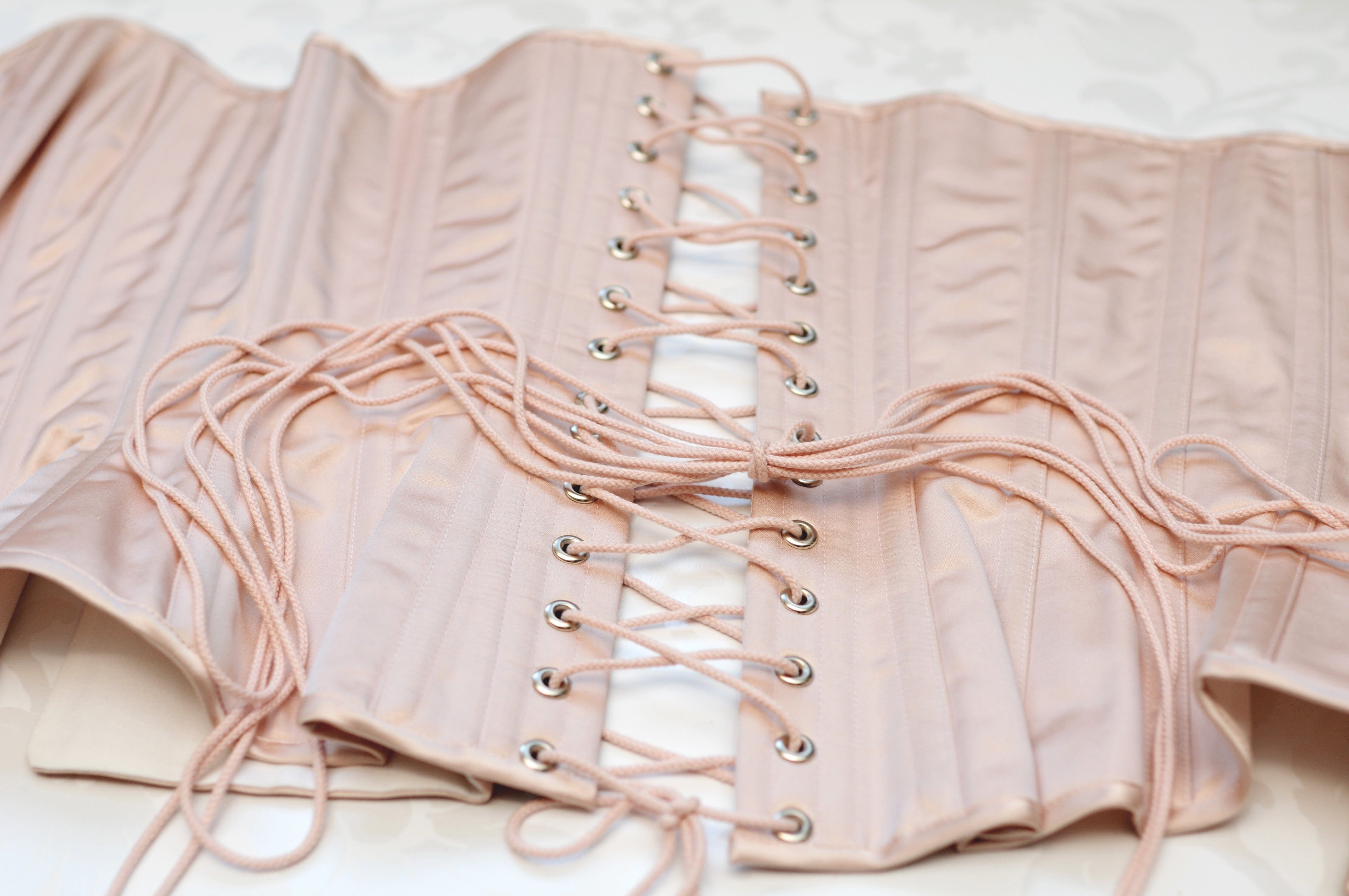 Pink corset lacing flatlay photo with 100% silk satin and corsetry coutil