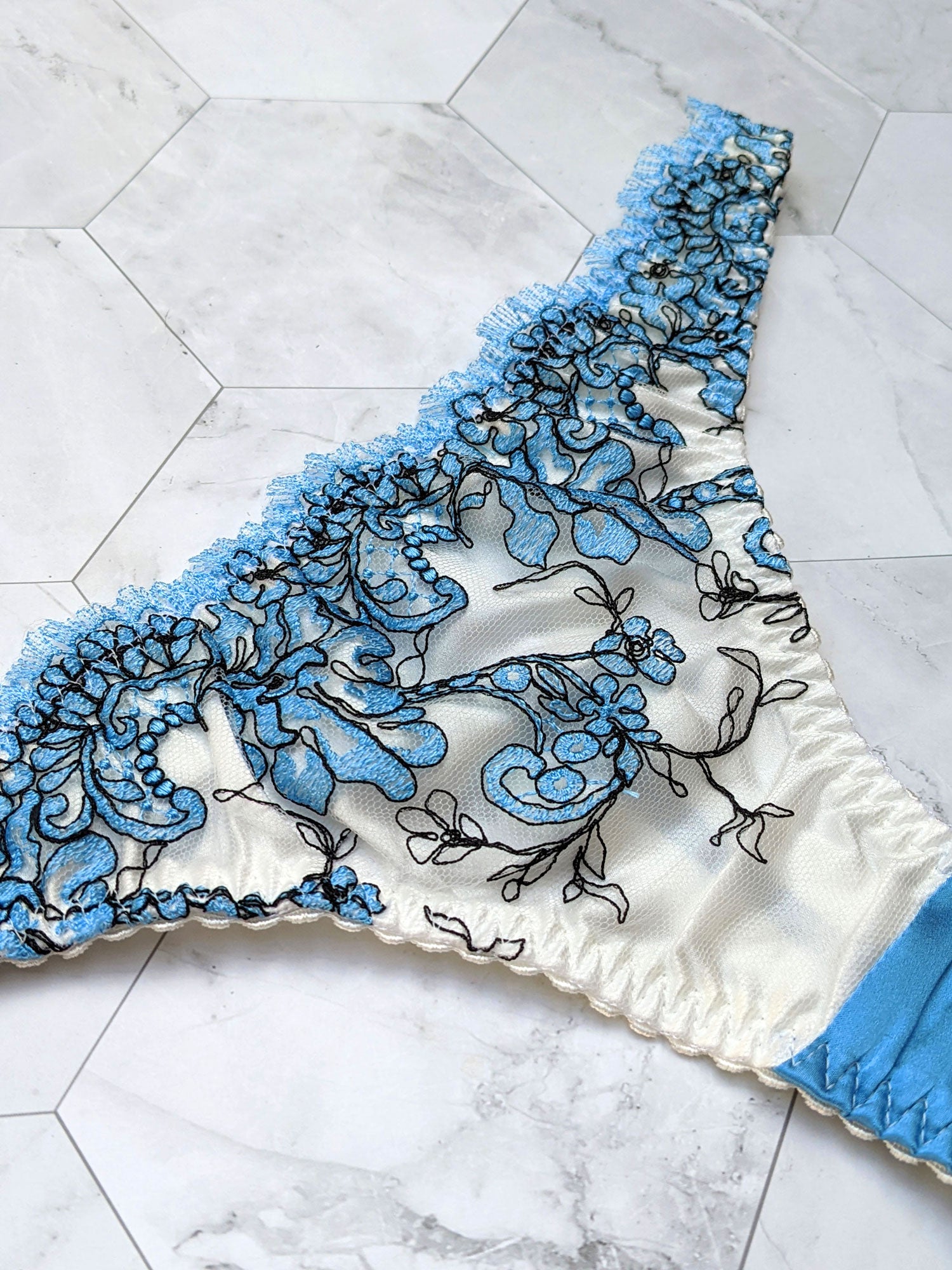 Embroidered blue thong with white silk lining