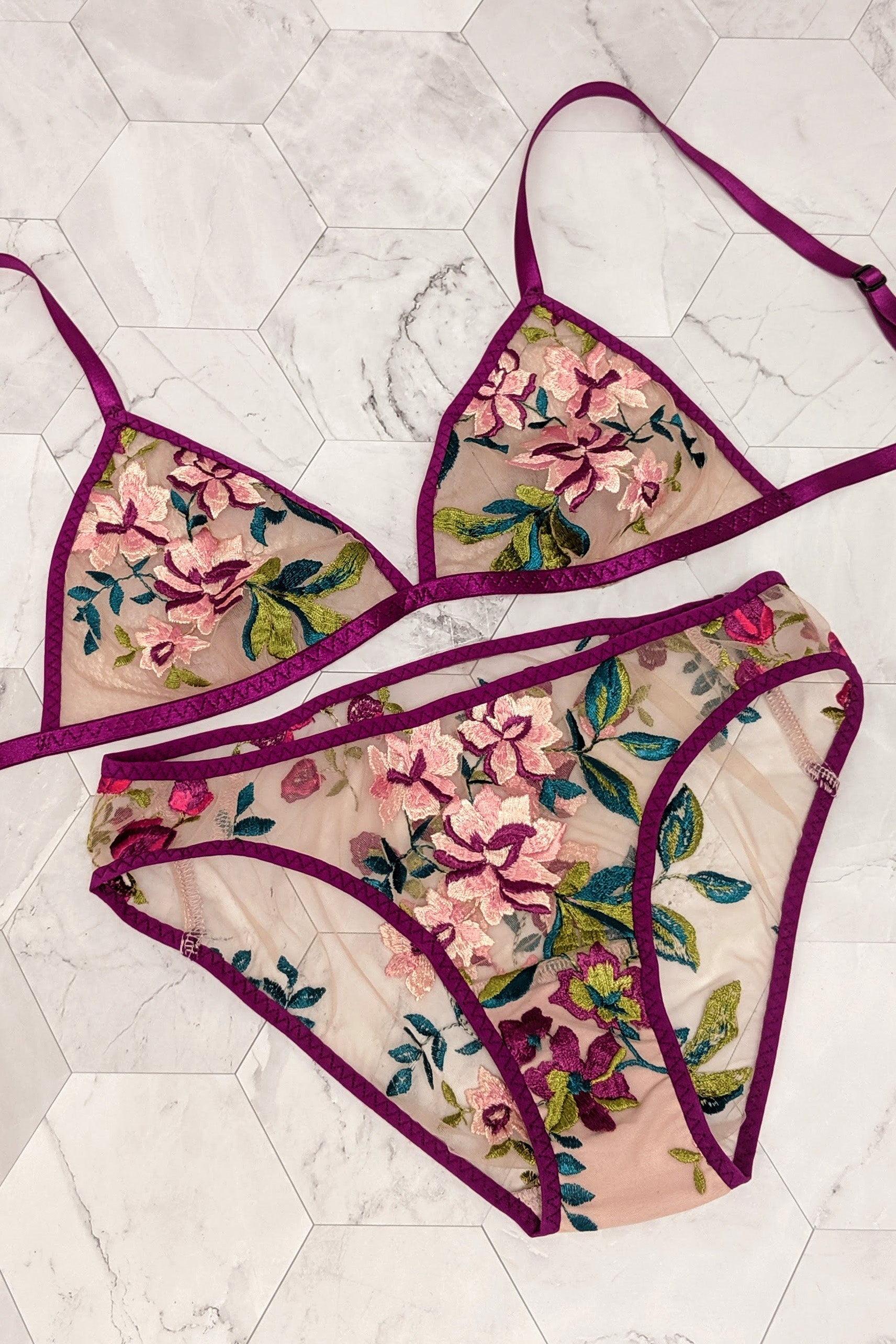 Pink and green embroidered lingerie set flat lay