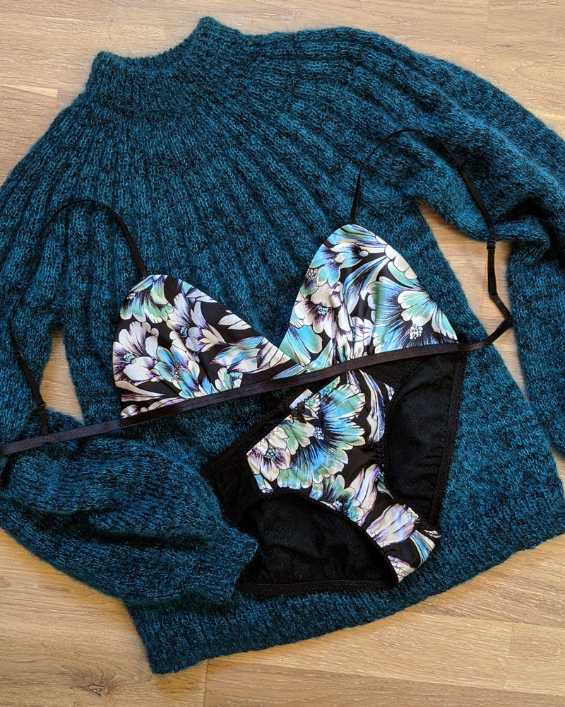 A silk bralette in a triangle vintage cut with a teal blue hand knitted sweater